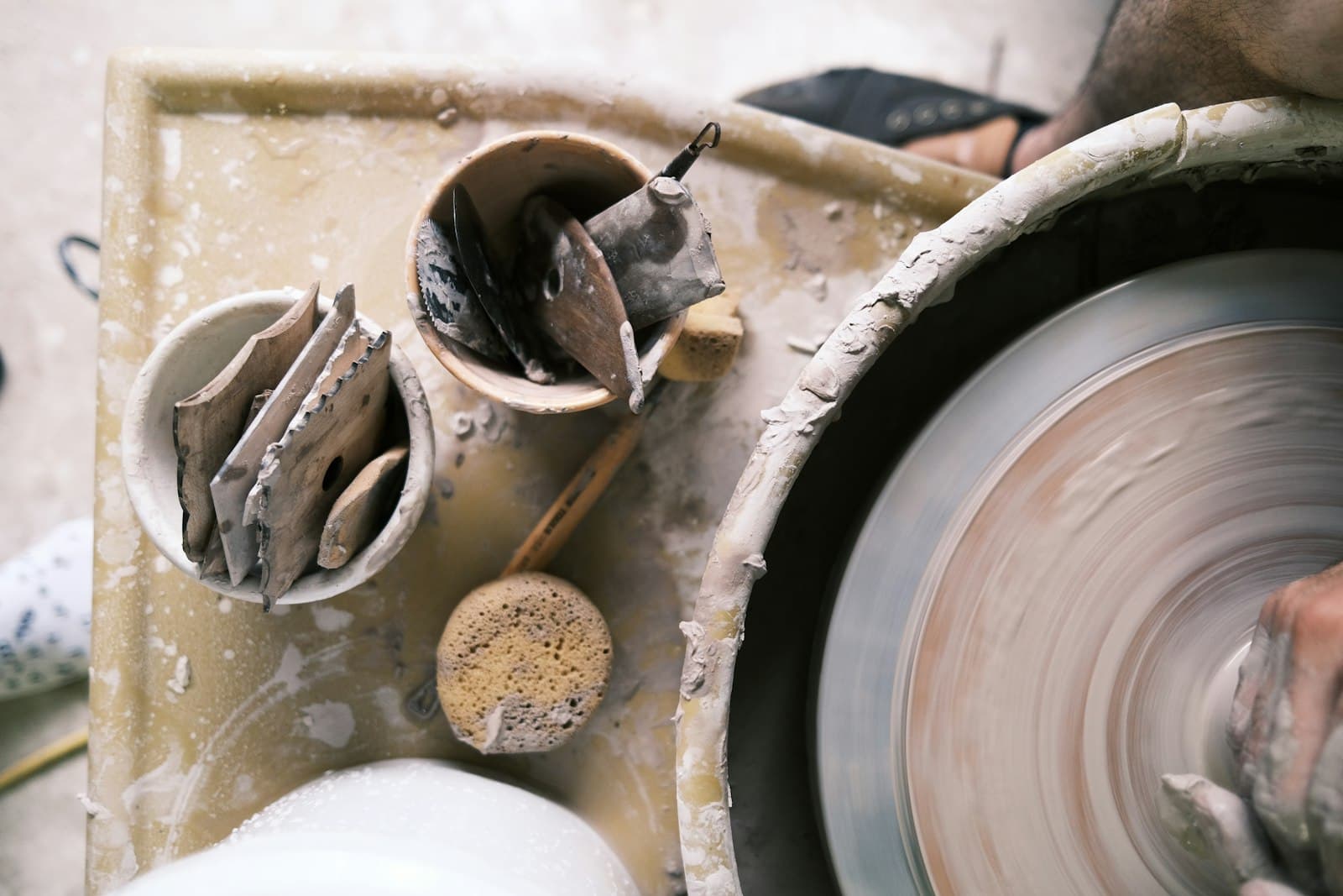 A potter shaping clay at the wheel